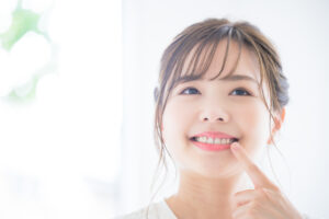 歯を指さしてチェックする女性