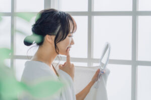 鏡で歯をチェックする女性