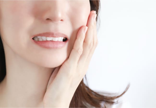 痛そうに頬をおさえている様子
