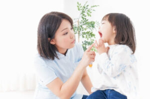 子供の口を見る女医