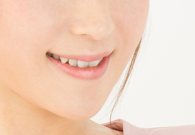 歯をみせて微笑む女性